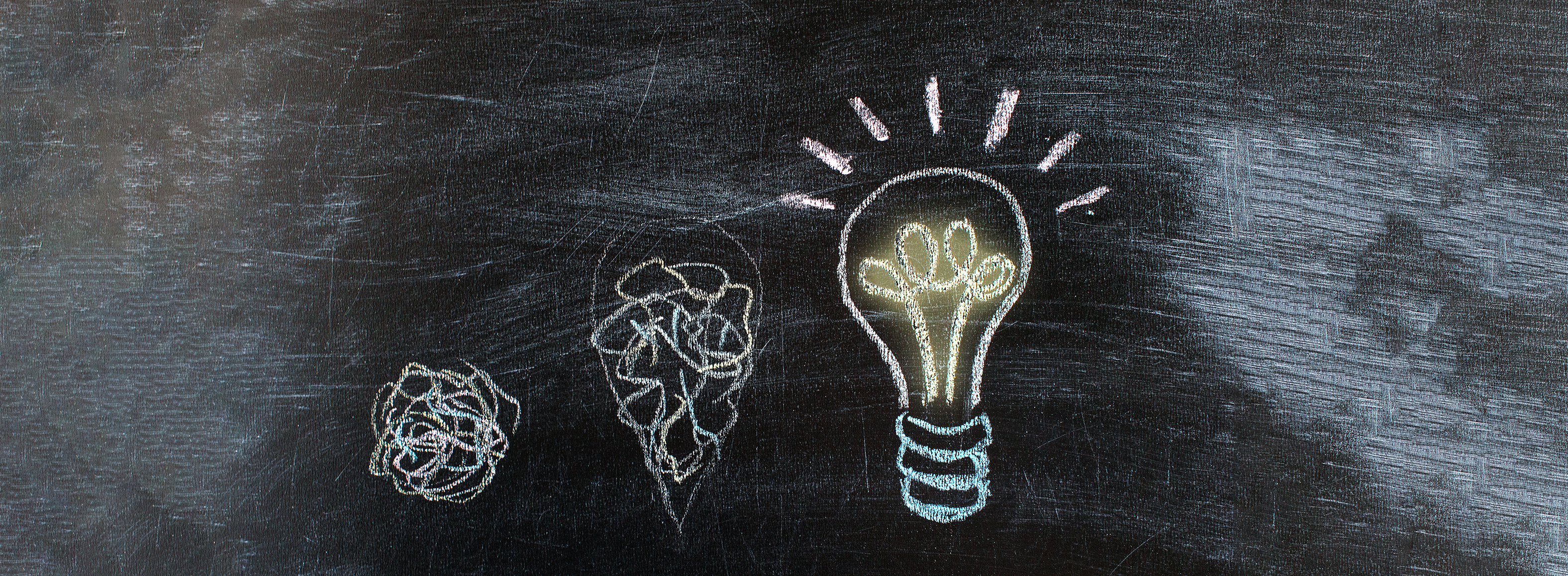 Op een schoolbord staat een gloeilamp getekend.