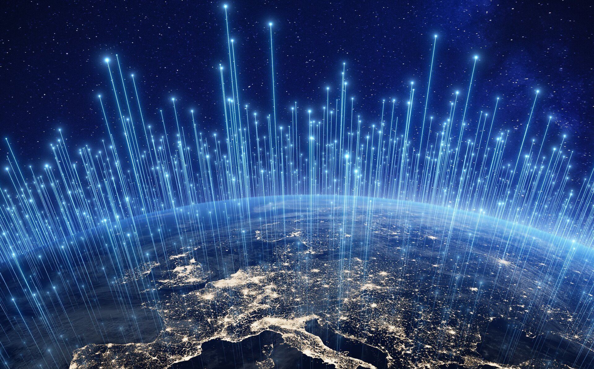 Een afbeelding van Europa bij nacht, gezien vanuit de ruimte. Lichtlijnen lopen van de ruimte naar verschillende plekken op aarde om satelieten aan te geven.