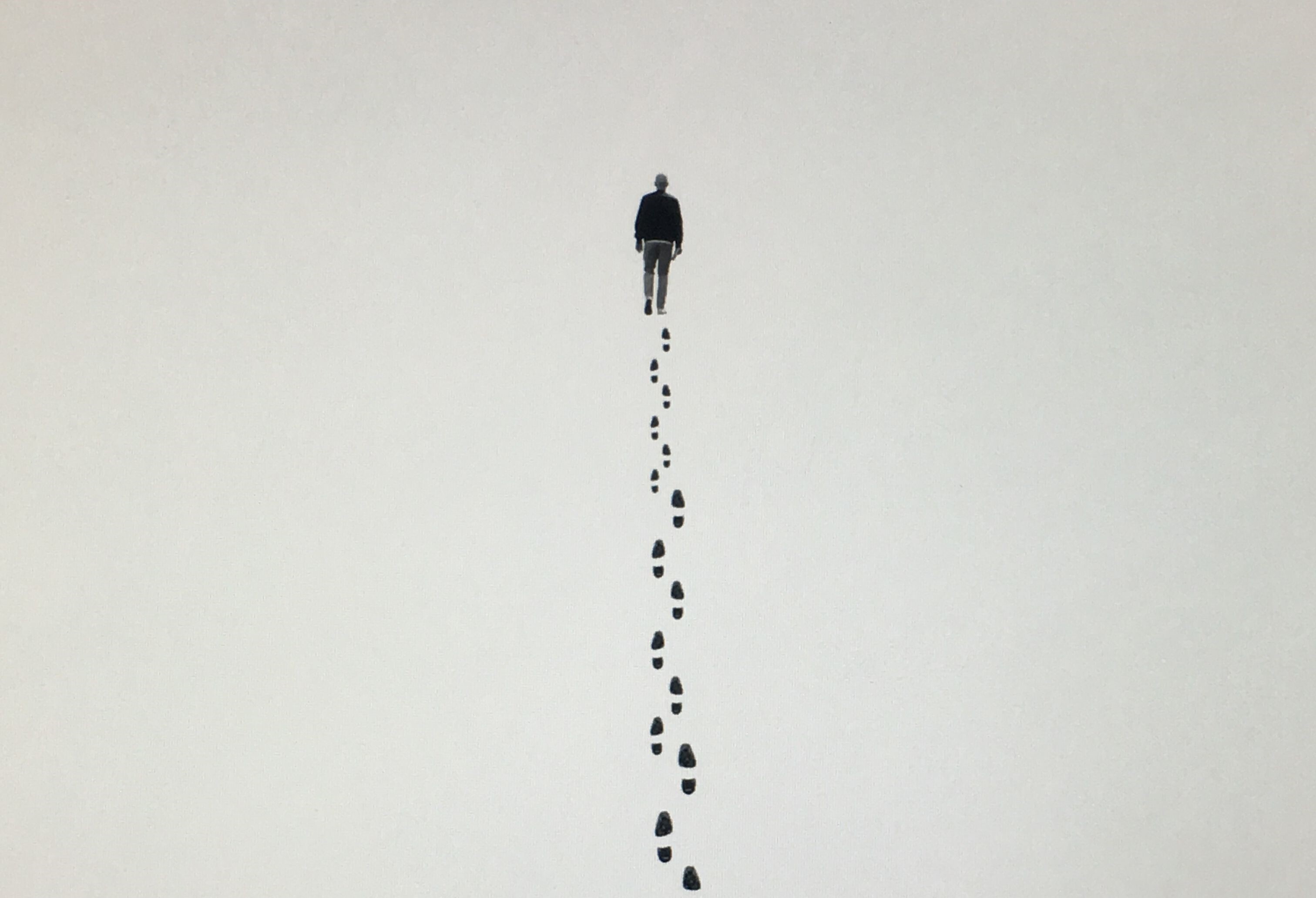 Een tekening van een persoon die aan het wandelen is. Er zijn voetsporen te zien.