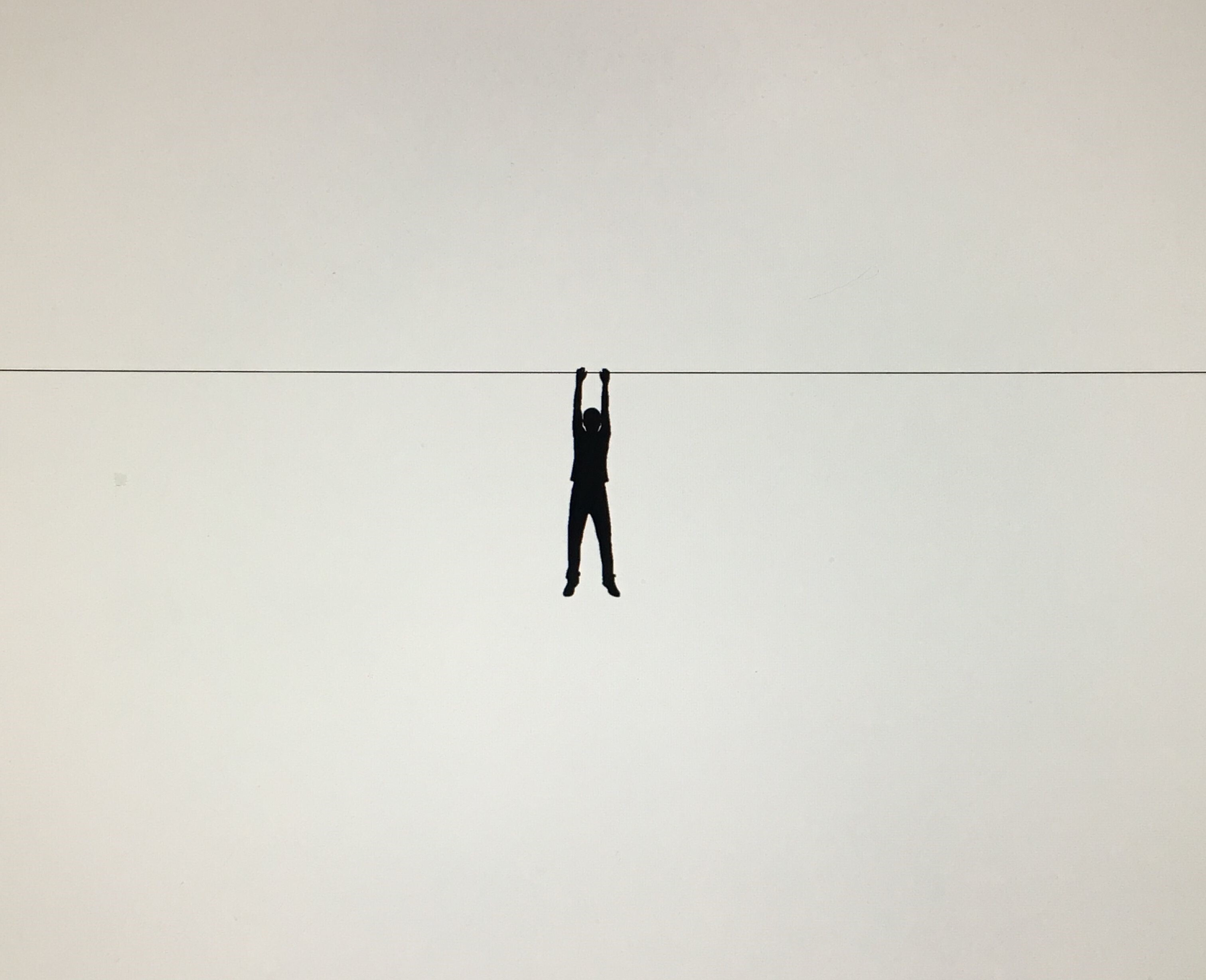 Een silhouet van een persoon die aan een draad hangt.