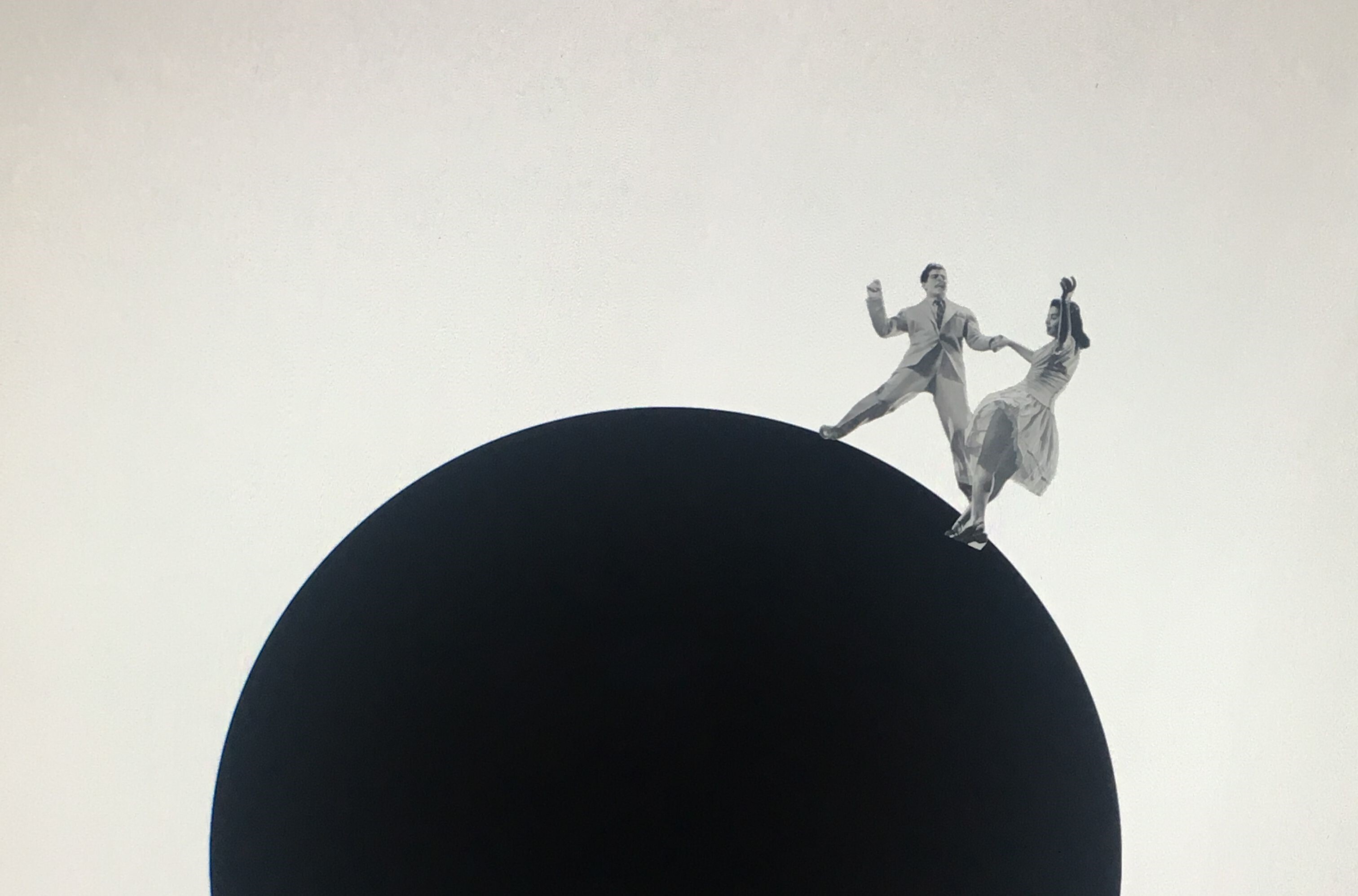 Twee mensen staan bovenop een zwarte cirkel.