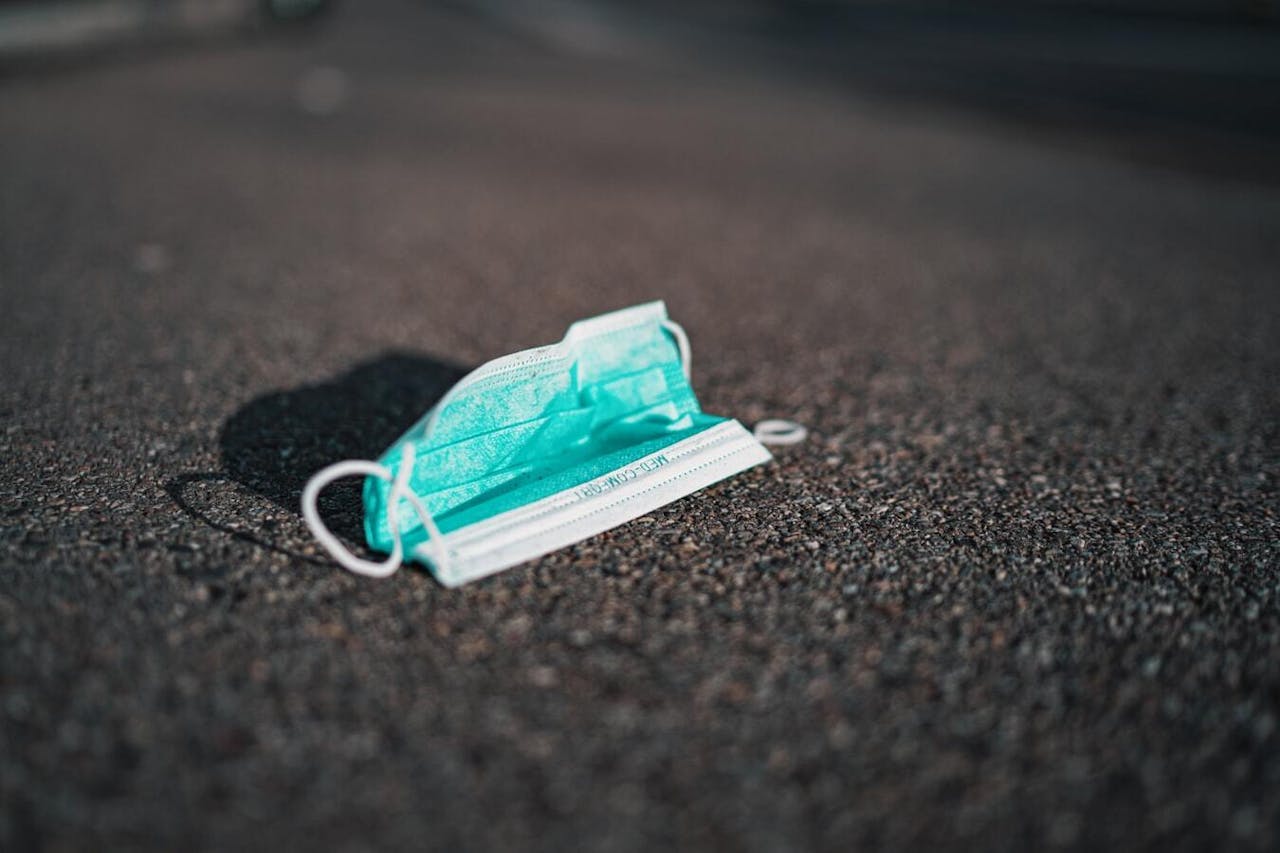 Een mondmasker dat op de weg ligt